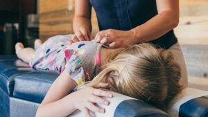 Person reviewing a headache diary beside a treatment table in a quiet clinical room.